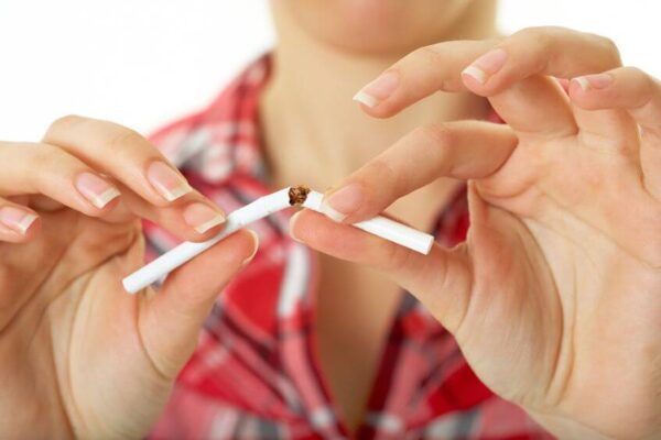 Vrouw breekt sigaret doormidden tussen stoptober en nieuwjaarsdag