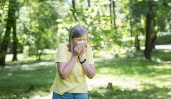 Vrouw niest door hooikoortsklachten die verergerd worden door roken
