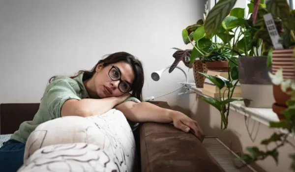 vrouw op de bank baalt van de hunkering naar een sigaret.